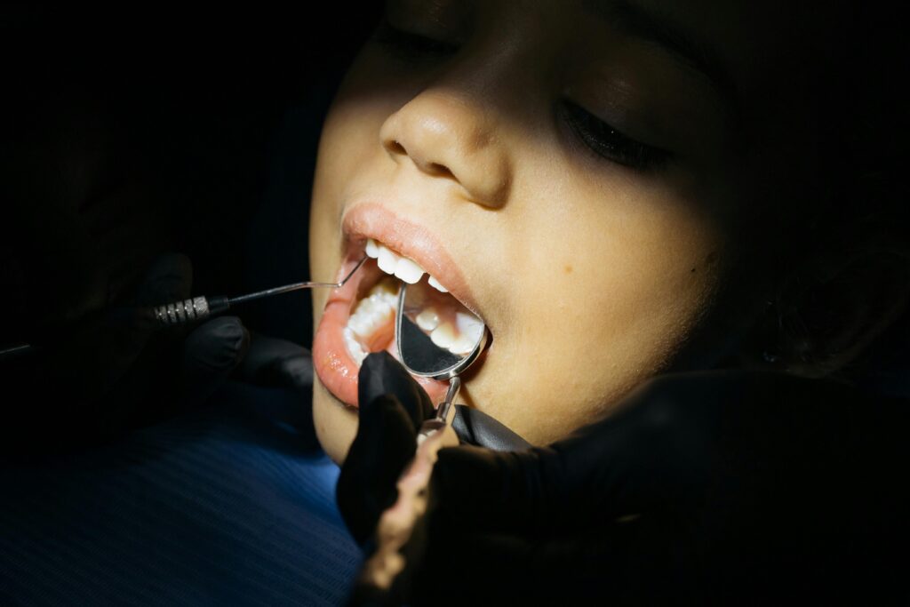 Close-up of a child undergoing a dental examination at a clinic.